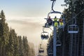 Happy skiers on chairlift above the clouds Royalty Free Stock Photo